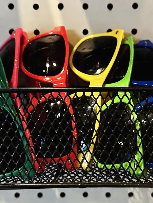 Colorful sunglasses for sale in a wire basket
